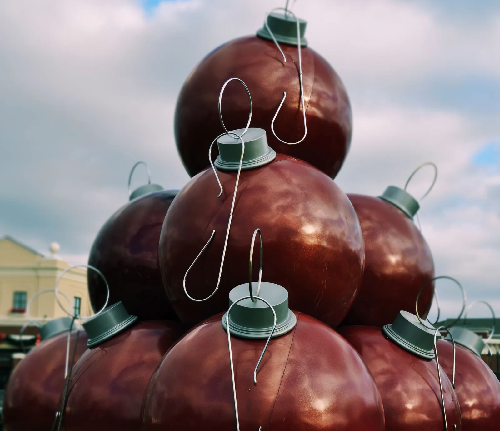 Giant Christmas ornament decorations stacked on the lawn at The Shops of Carriage Crossing in Collierville.
