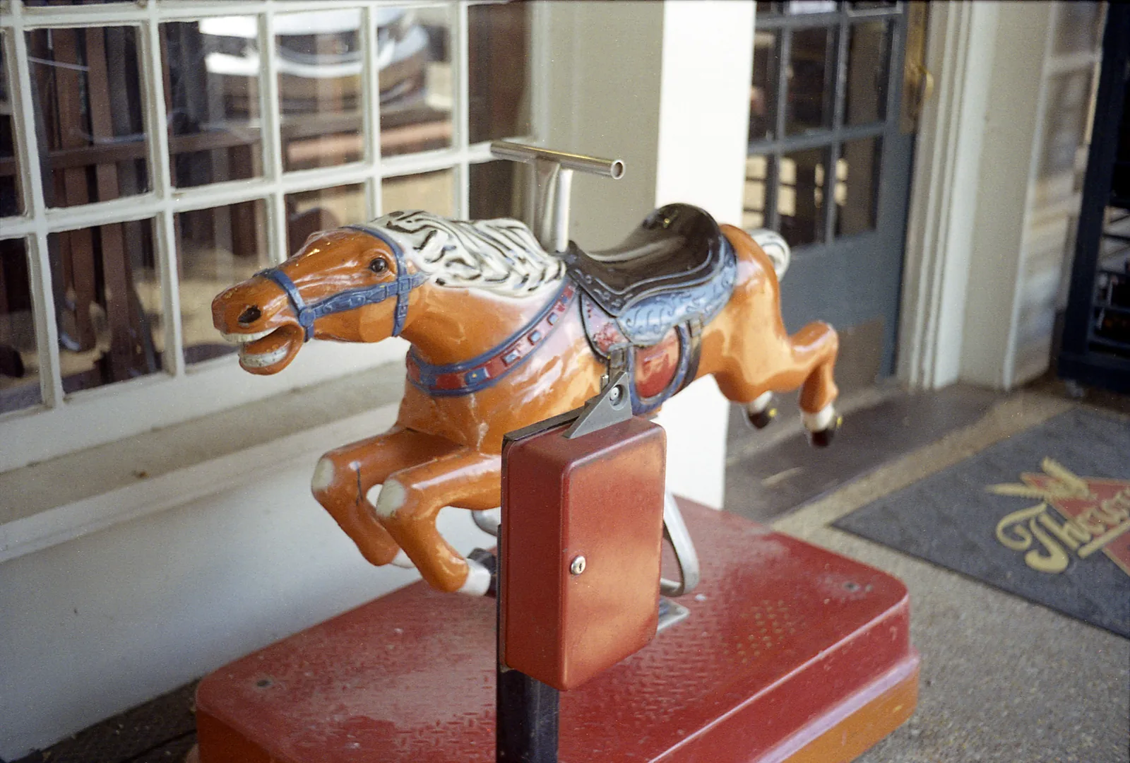 A vintage coin-operated horse ride outside a shop doorway on the Collierville Town Square.