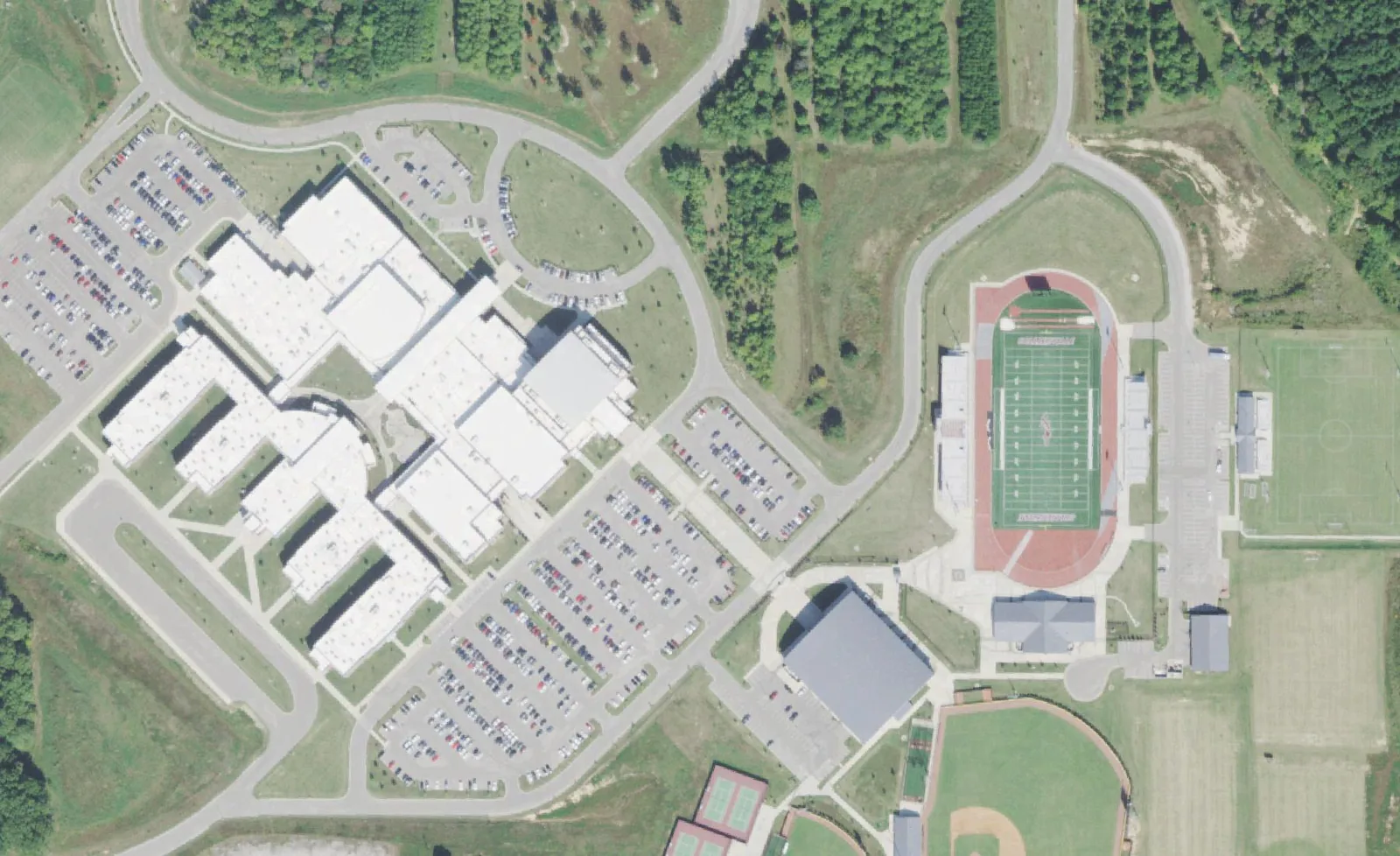 Collierville High School's campus off Shelby Drive from the air, with the football stadium and its red track at right.