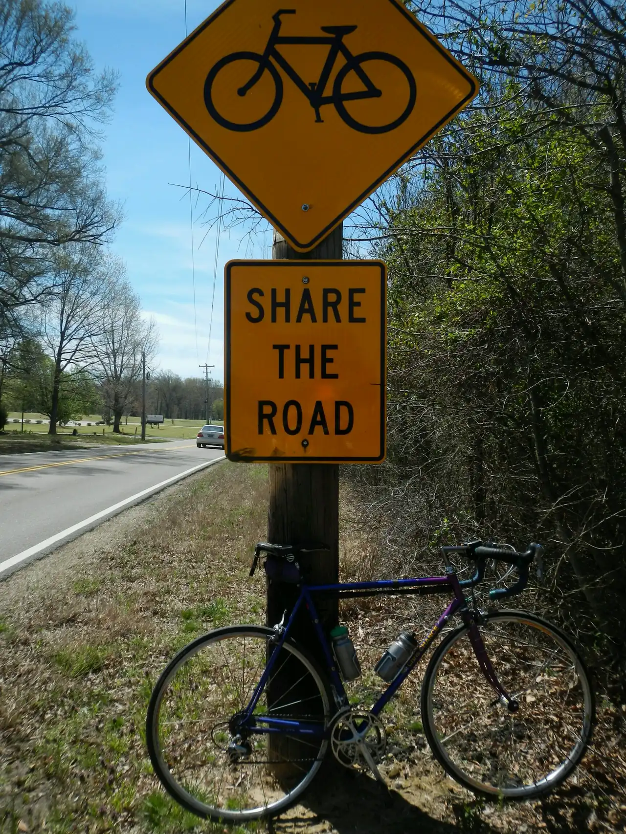 A Share the Road sign and a parked bicycle where Byhalia Road meets Shelby Drive (State Route 175) in Collierville.