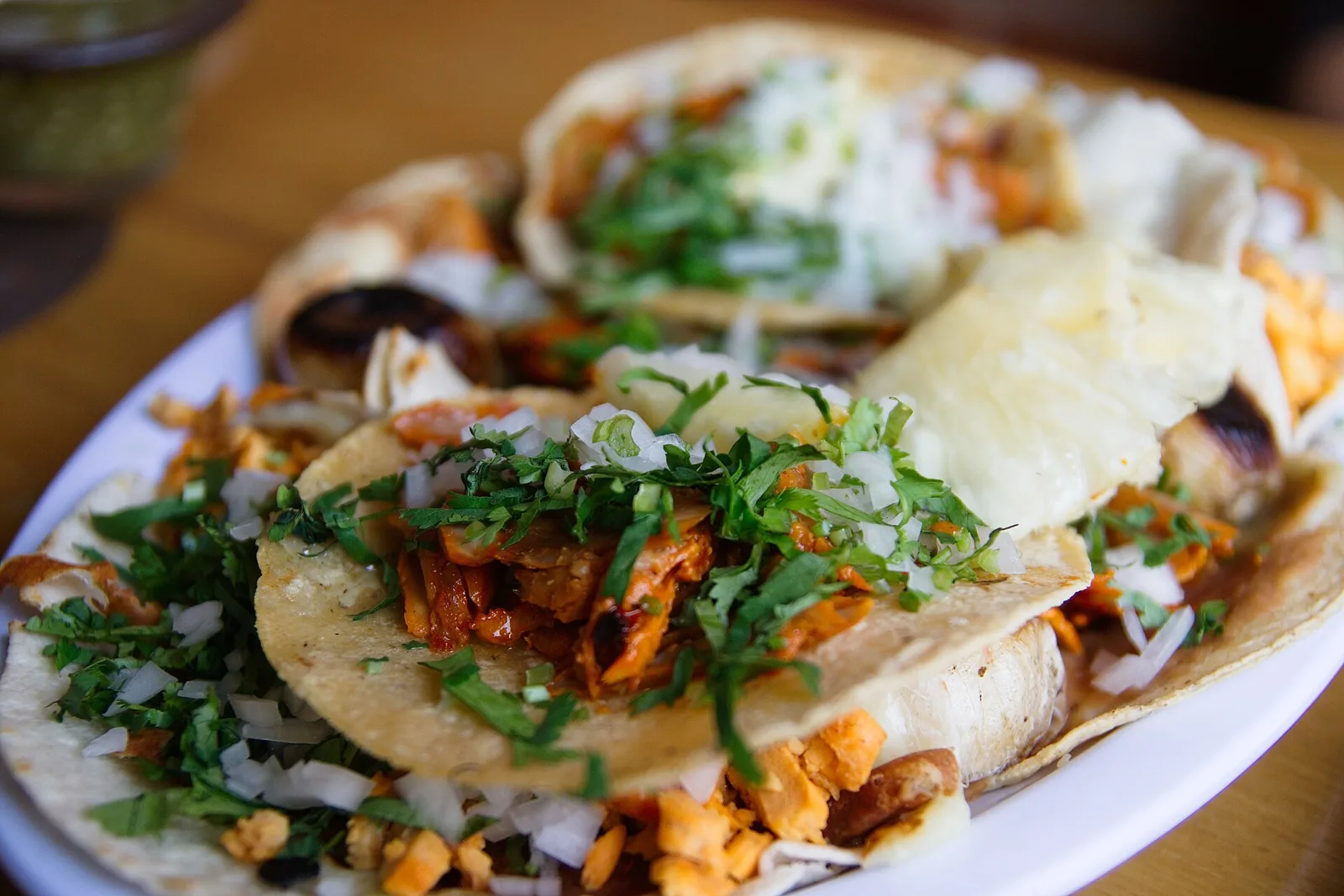 Tacos al pastor with onion, cilantro and lime on a plate.