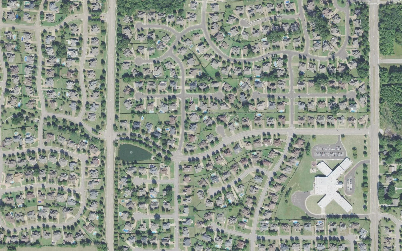 Estanaula Trails in Collierville from the air: curving streets of homes and ponds, with Sycamore Elementary School at right