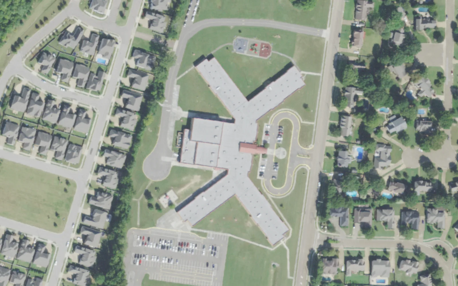 Bailey Station Elementary School's X-shaped building, playground and parking lots on Bailey Station Road in Collierville, seen from the air.