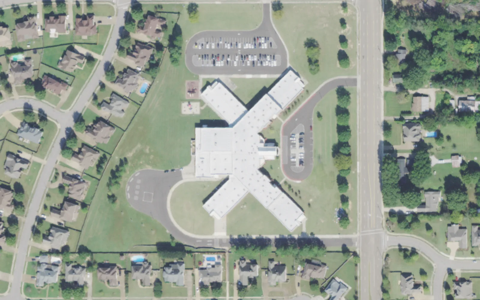 Sycamore Elementary School's X-shaped building and parking lots on Sycamore Road in Collierville, seen from the air.