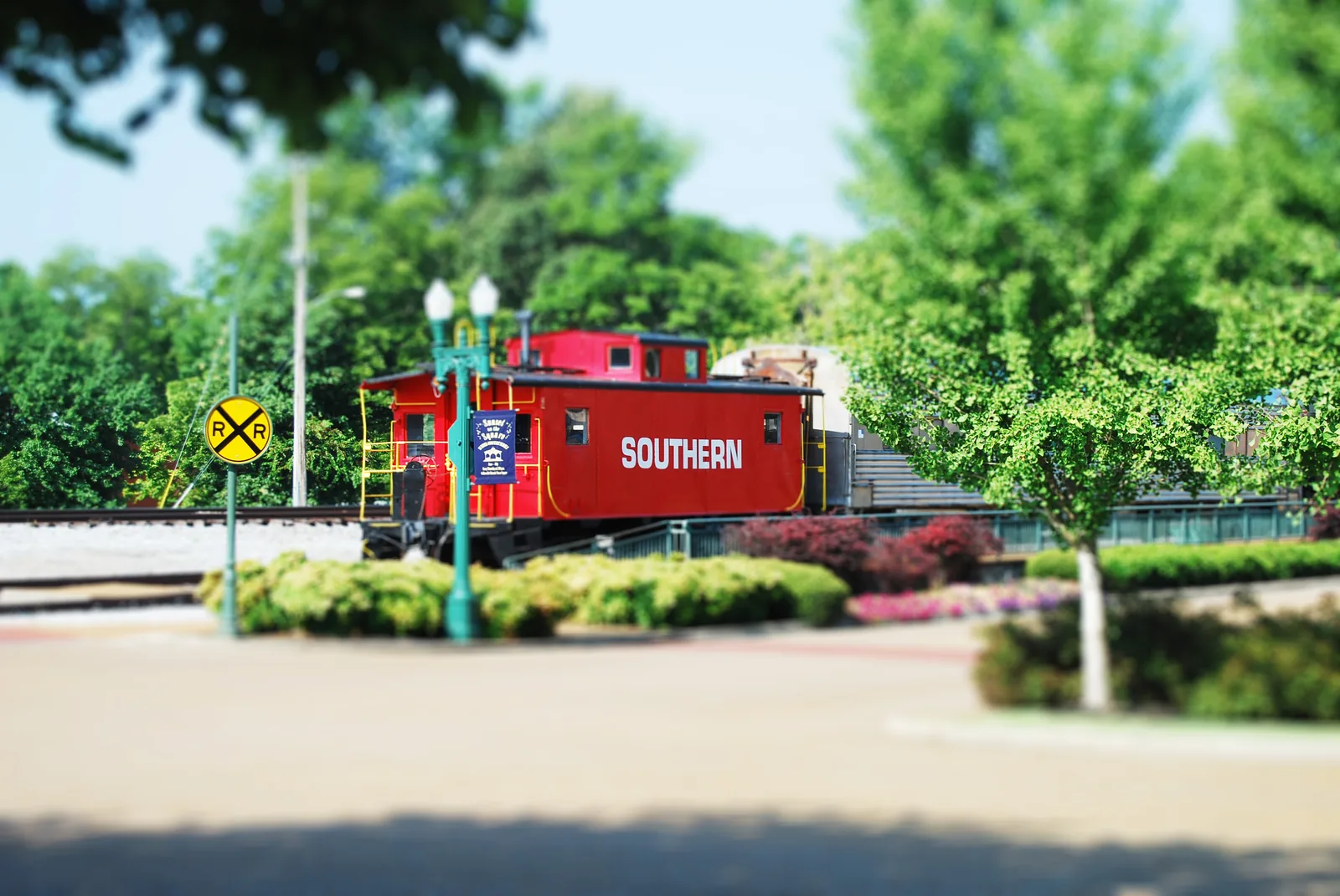 The red Southern caboose and depot grounds on the Collierville Town Square, shown in a tilt-shift photograph.